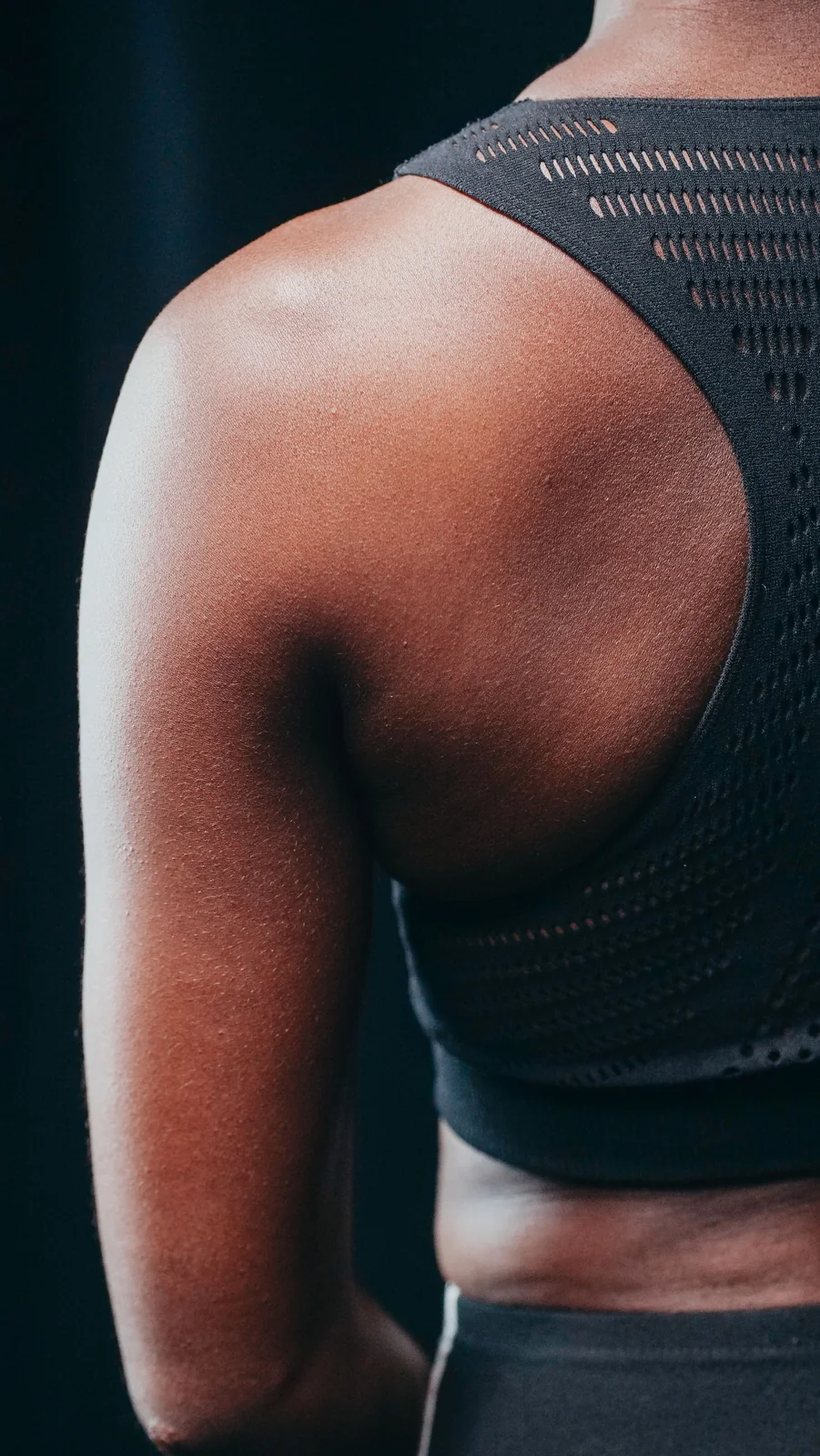 Close-up of breathable black athletic fabric worn during a workout.
