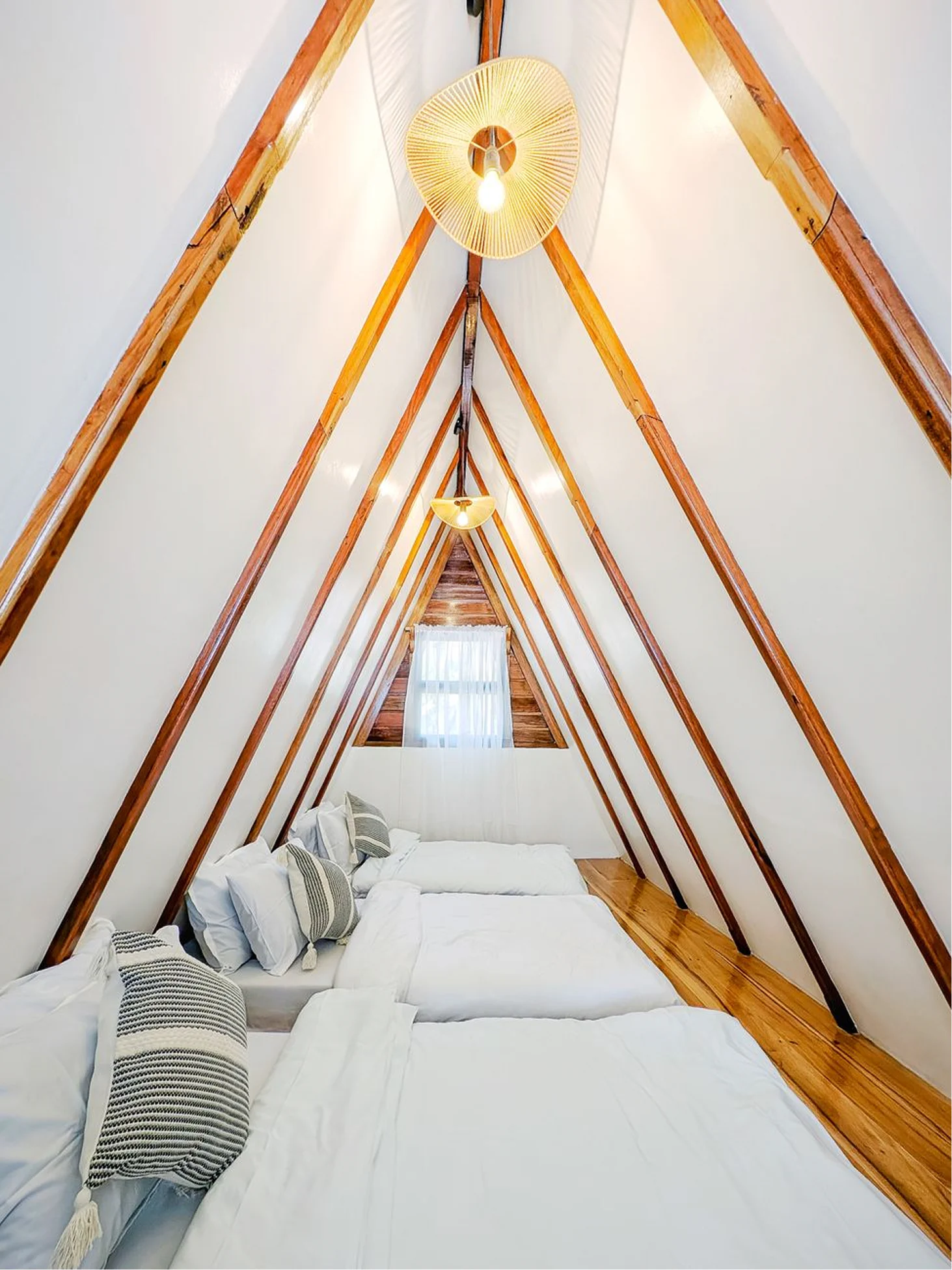 Bright resort bedroom with simple furniture, soft bedding, and a relaxing view.