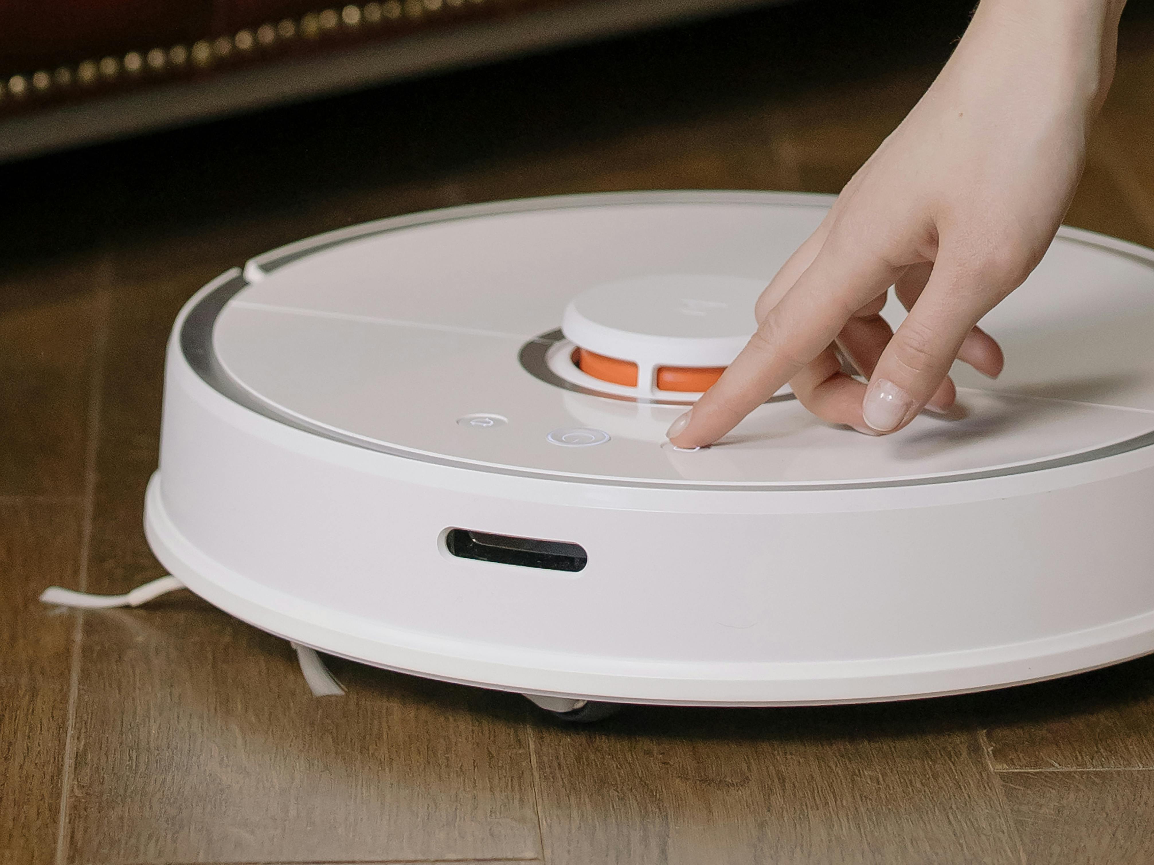 Woman turning on a robot vacuum
