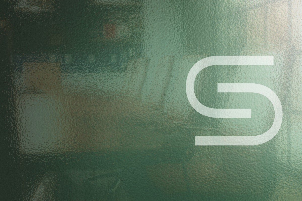 woman in blue tank top standing beside white wall