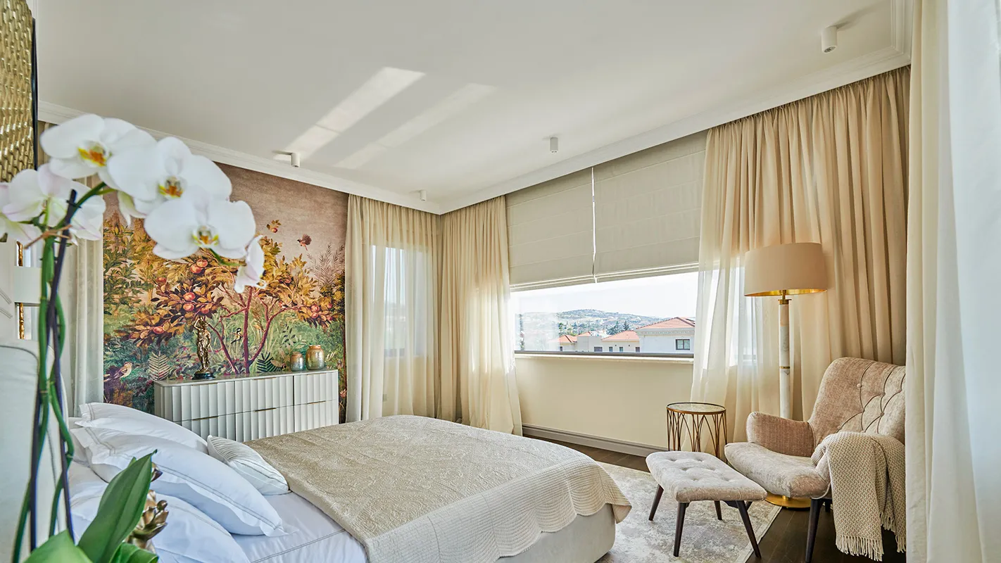 Villa Belmare bedroom with panoramic wall mural, soft drapery, and a cozy reading corner
