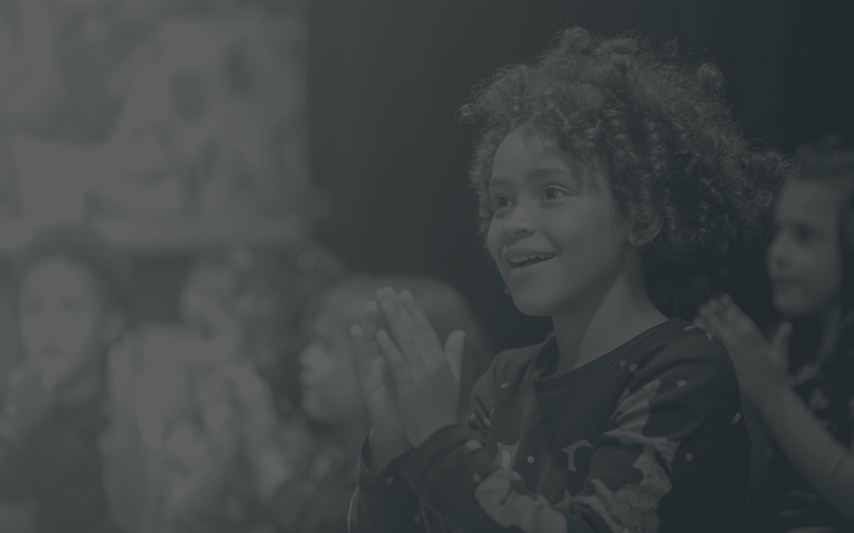 A black-and-white photo featuring a woman smiling amid a crowd, with artistic textures and shadows.