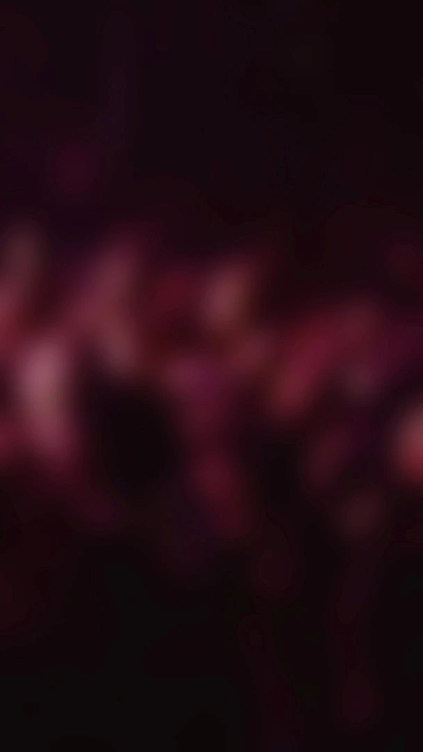 Abstract red and dark gradient background with soft blurred light shapes, creating a moody, atmospheric visual texture.