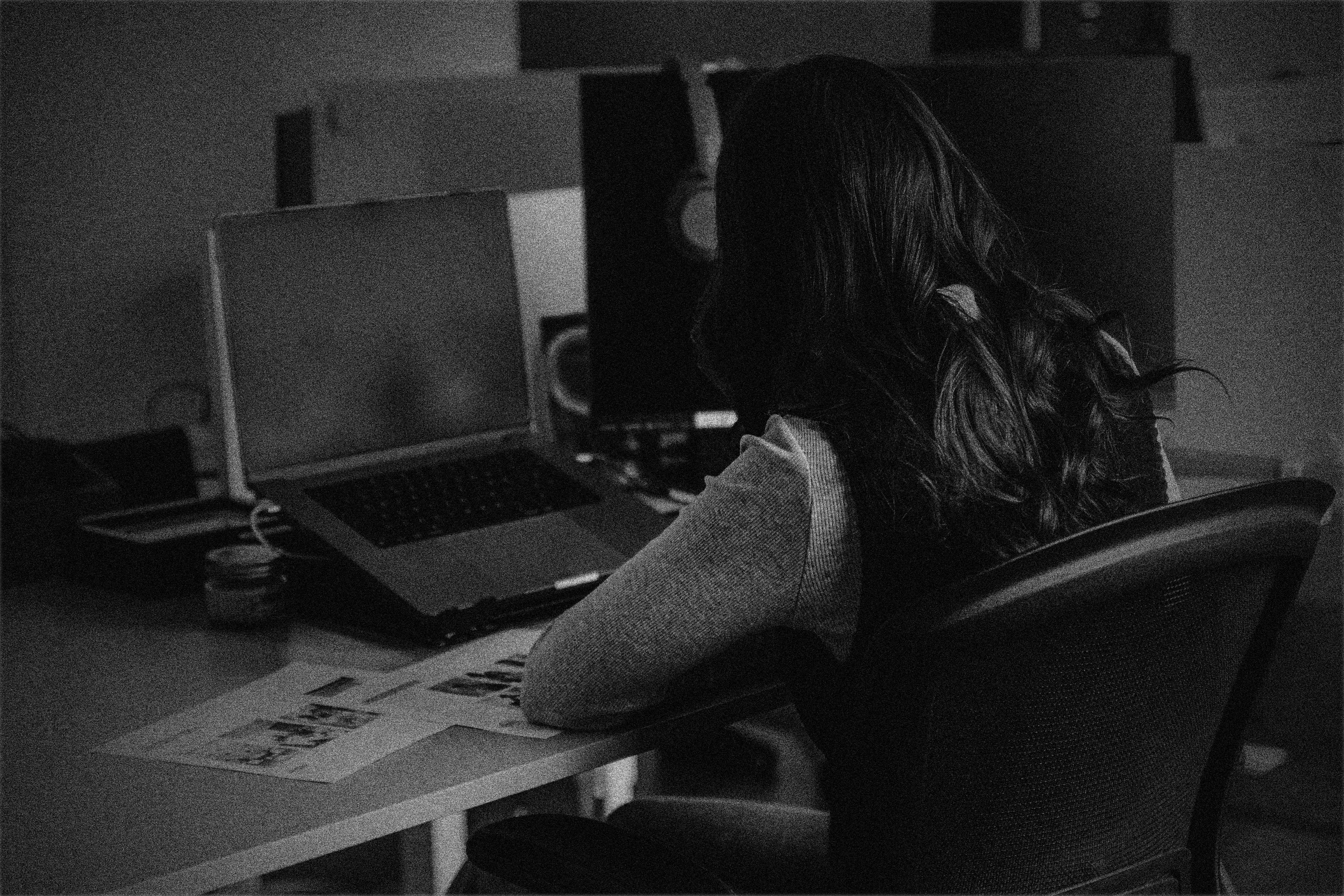 Collaborative work session overhead view of six people collaborating at a rustic wooden table with coffee, papers, and a laptop