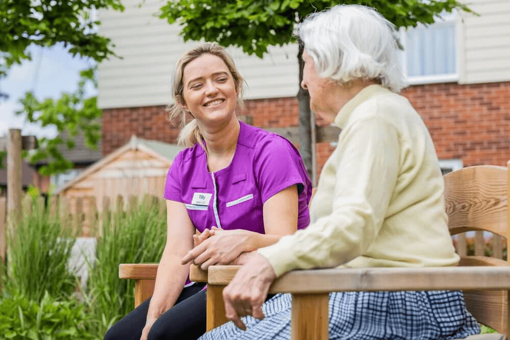 Two people sitting on wooden benches outdoors.