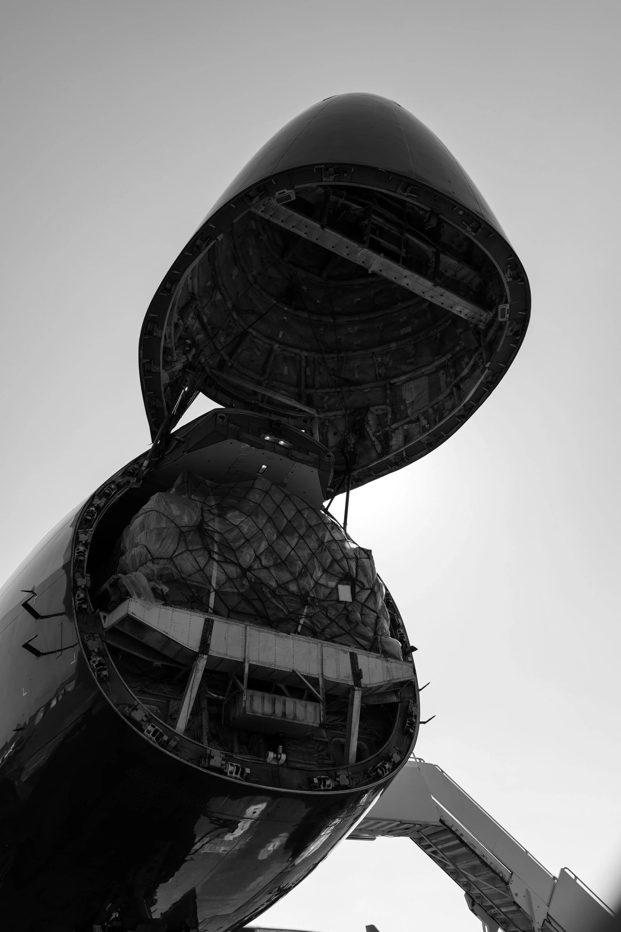 Close-up of a small aircraft nose and propeller engine shot from a low angle against a clear sky