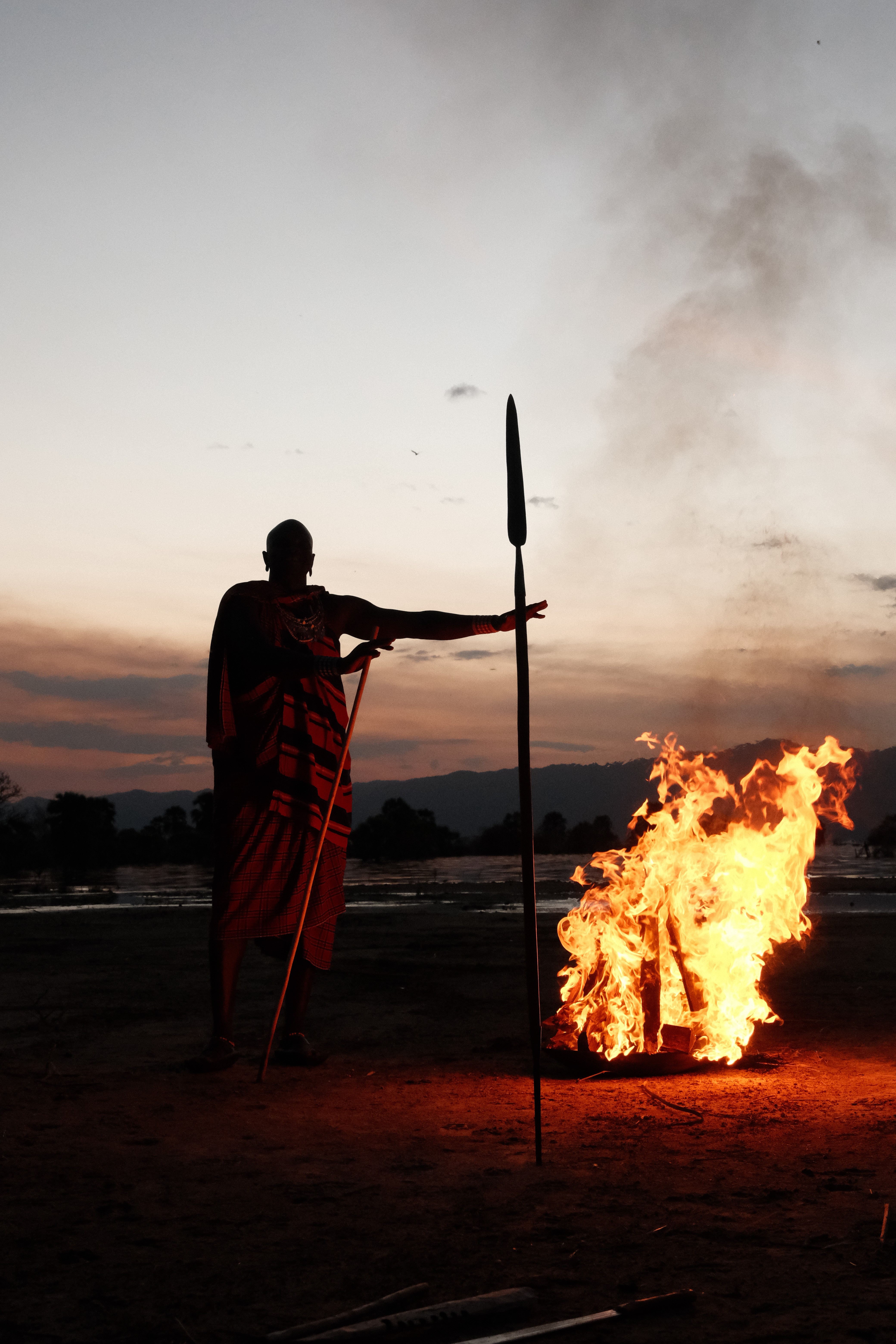 A girl holding a vintage-style camera while smoking a cigarette.