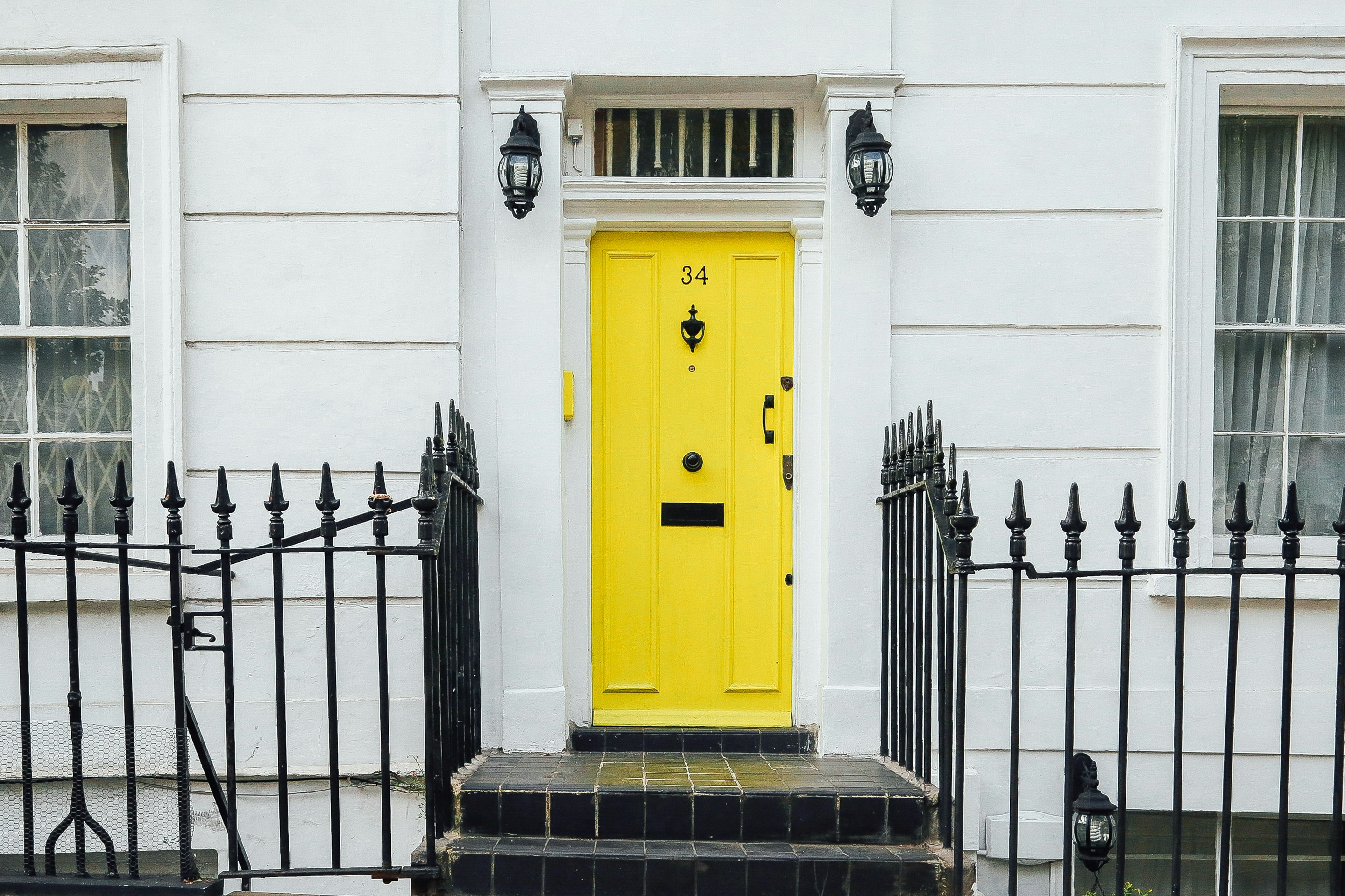 A bright yellow apartment door against white painted walls. 