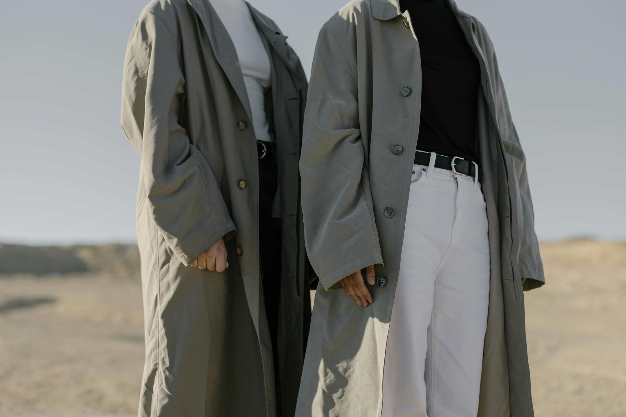 Models in clothing standing in a desert landscape.