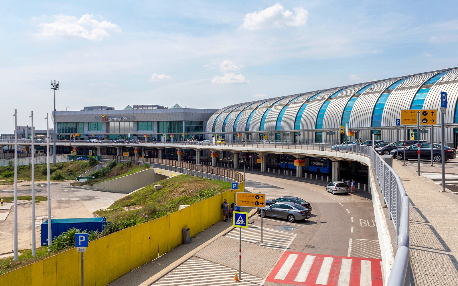 Exterieur van Terminal 2B van luchthaven Boedapest met auto's en bussen voor privétransfers.