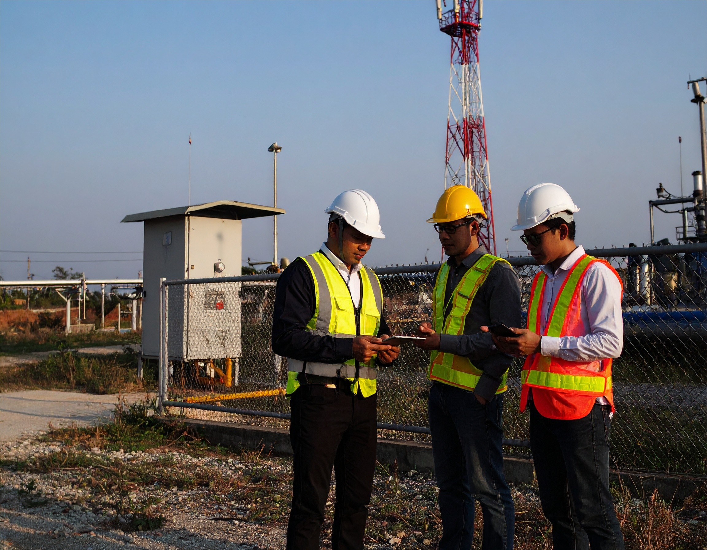 3 technicians discussing while examining devices