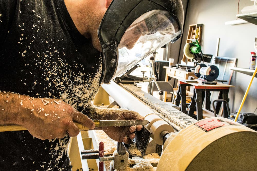 Carpenter wearing protective helment working on wood