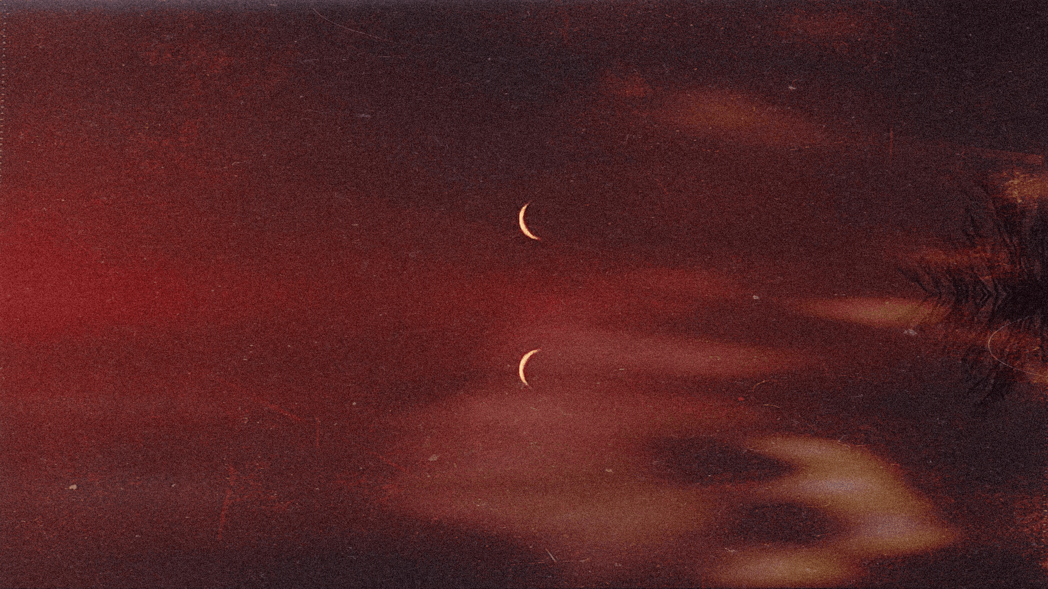 Zdjęcie symbolizujące hipnozę - czerwone niebo, fragme nt drzewo, widoczne dwa księżyce