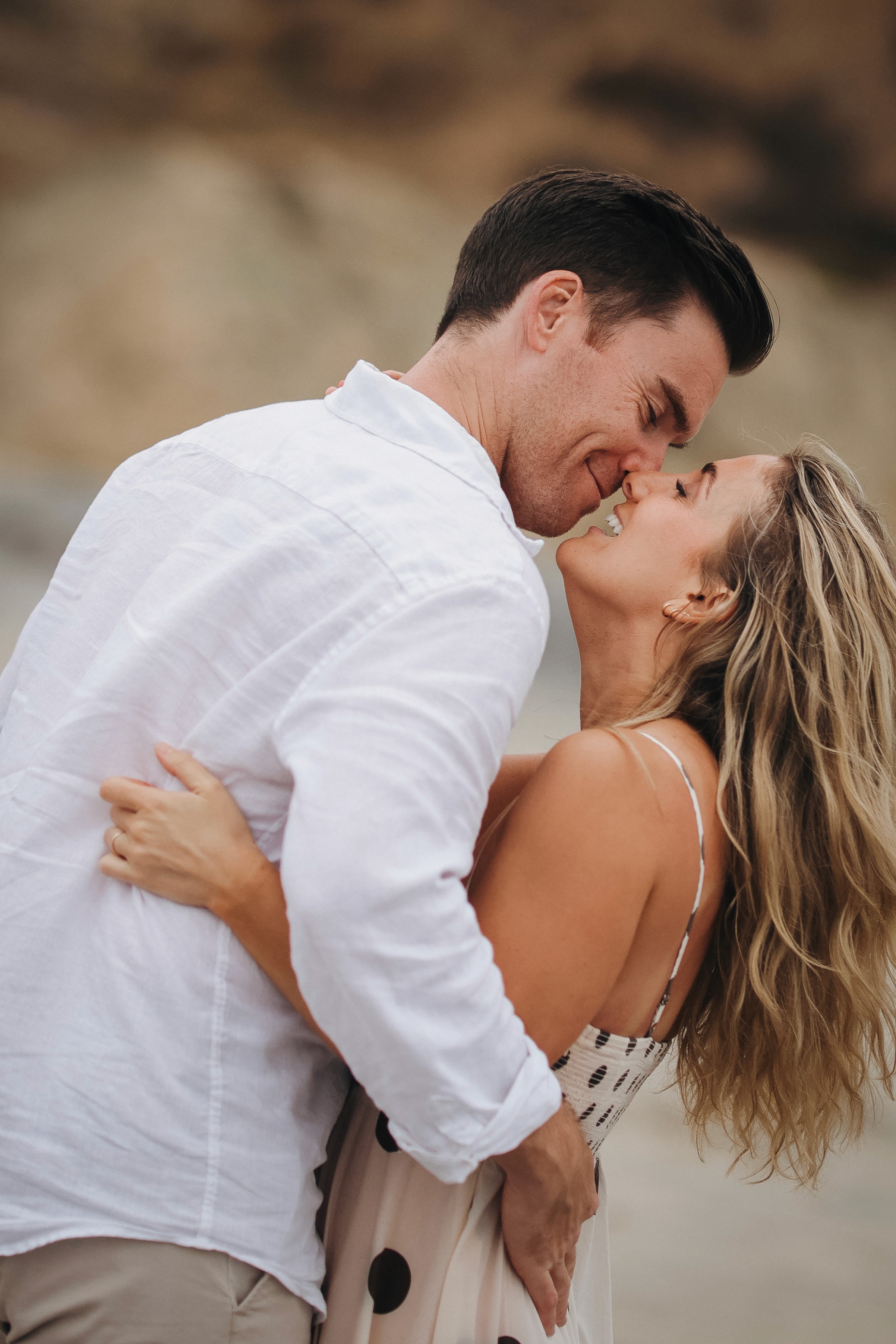 Couple holding each other during a warm golden-hour family session in Del Mar.