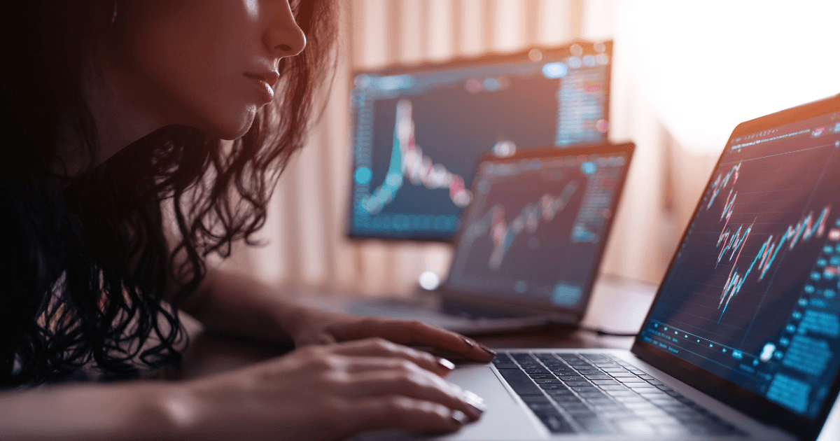 Woman looking at social impact measurement stats on three screens