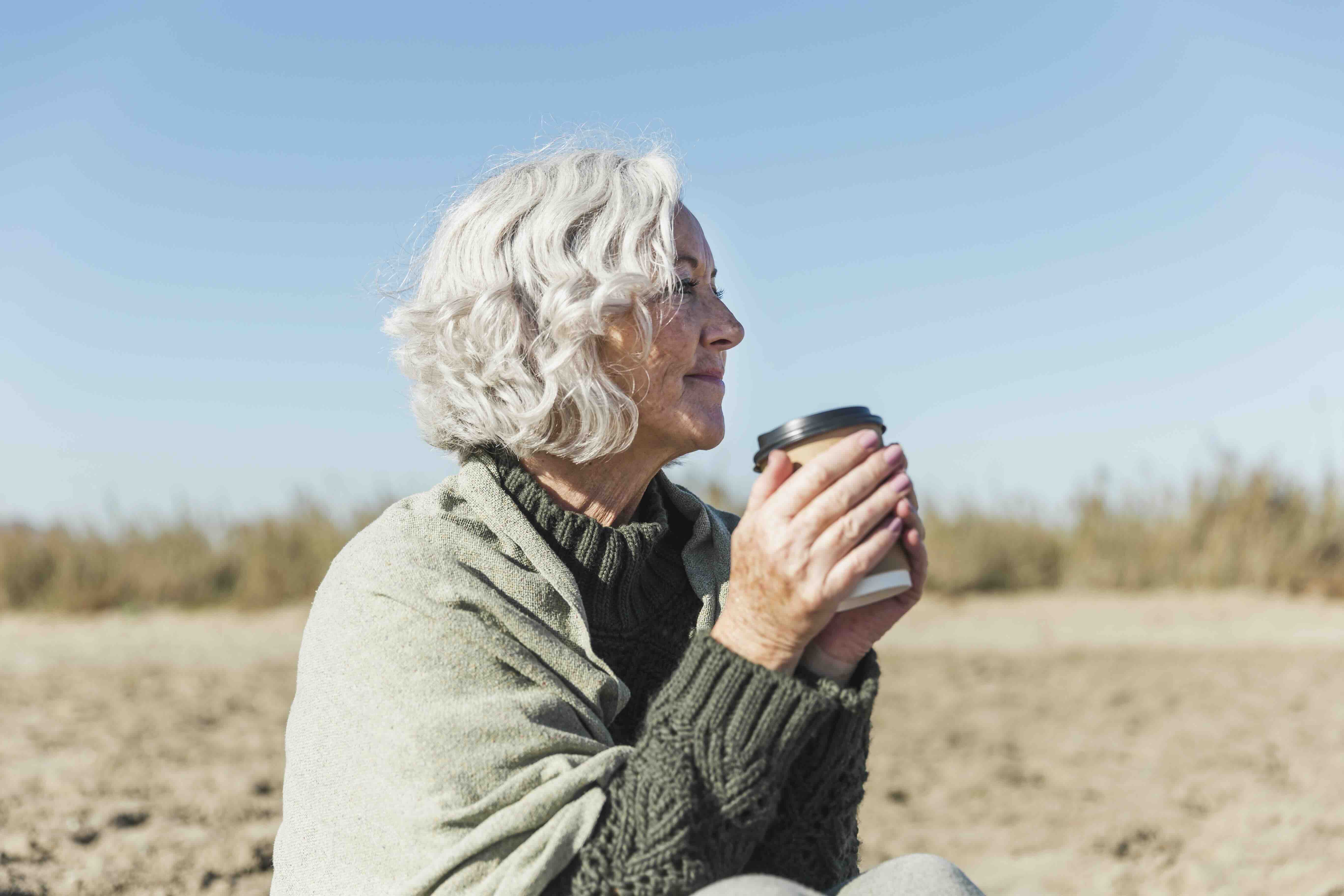 Older women at the beach with a cup
