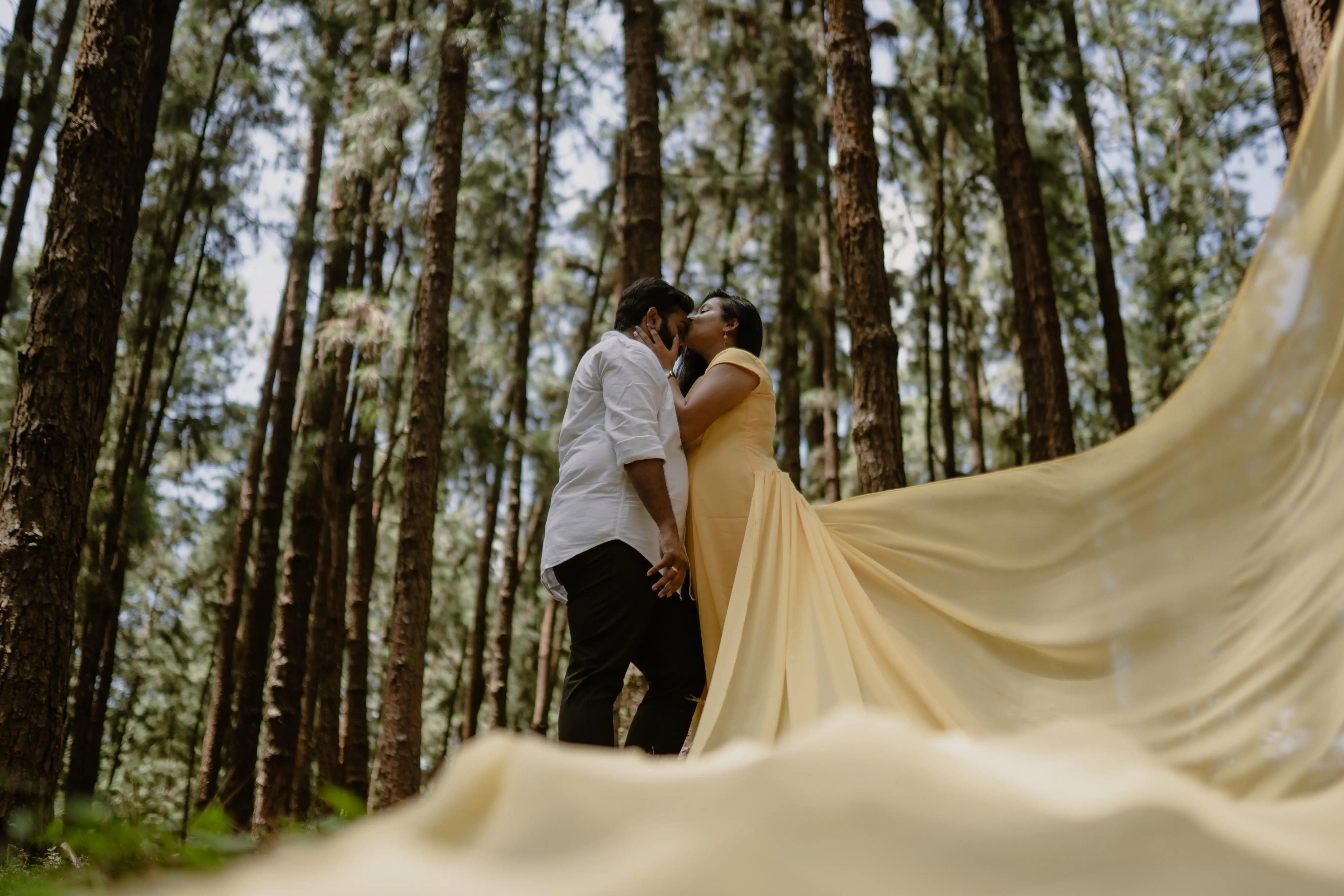 A romantic pre-wedding shoot in a vibrant forest, showcasing a couple's love, beautifully photographed by a wedding expert. Photo by Out of The Blues Fine Art Wedding Photography in Hyderabad.