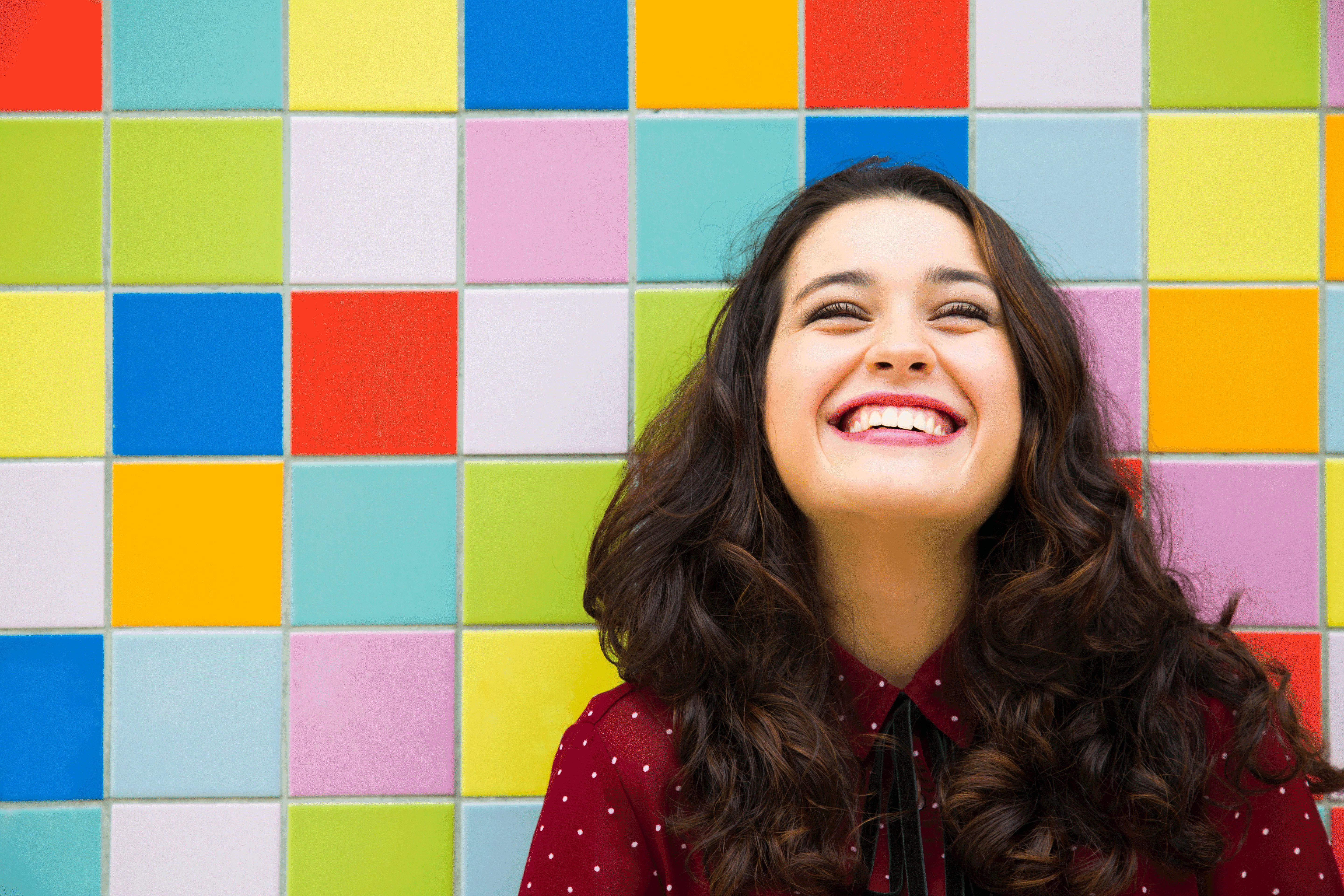 woman smiling in front of colorful background