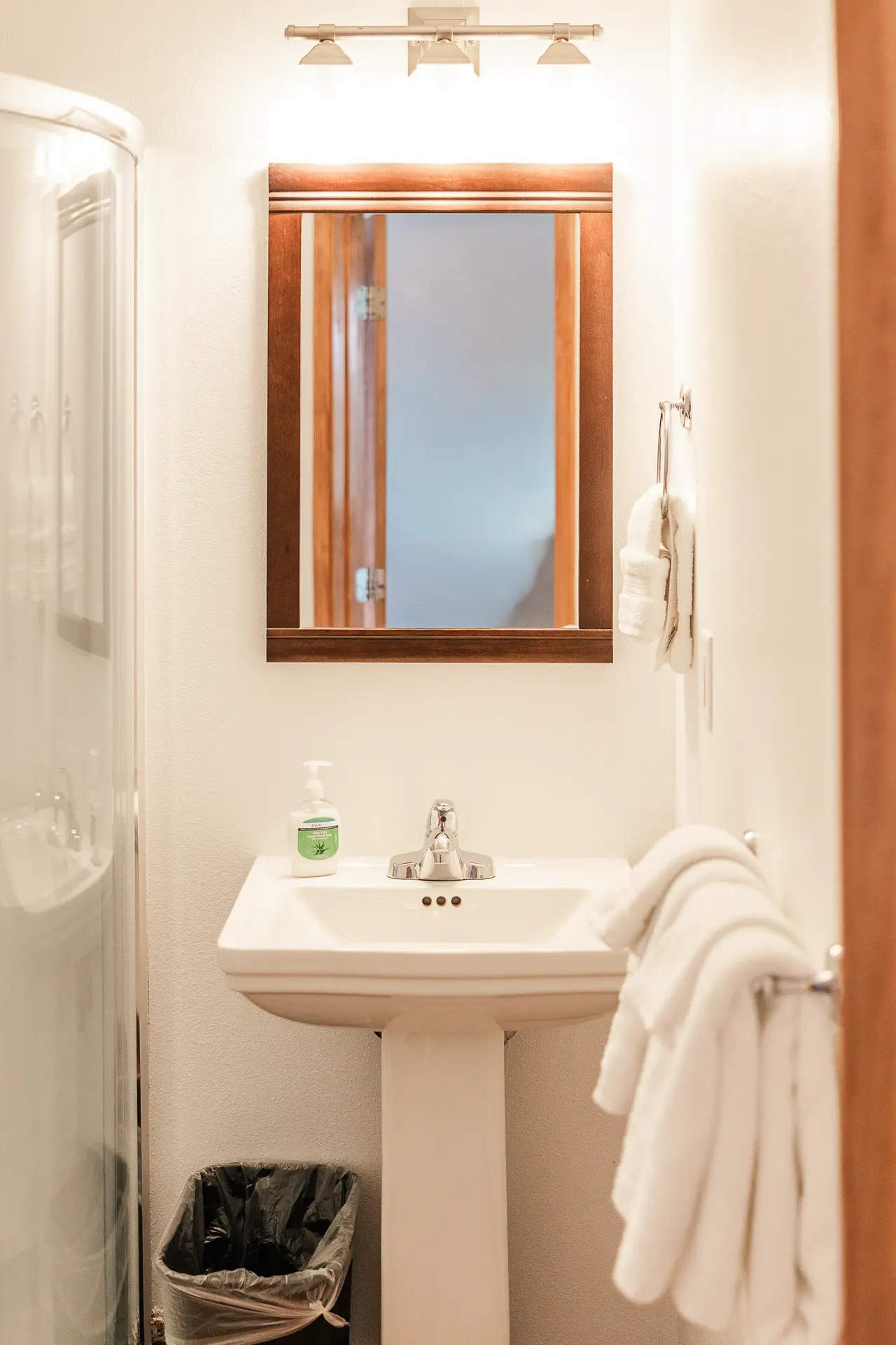 Bathroom vanity with wood-framed mirror and fresh towels.
