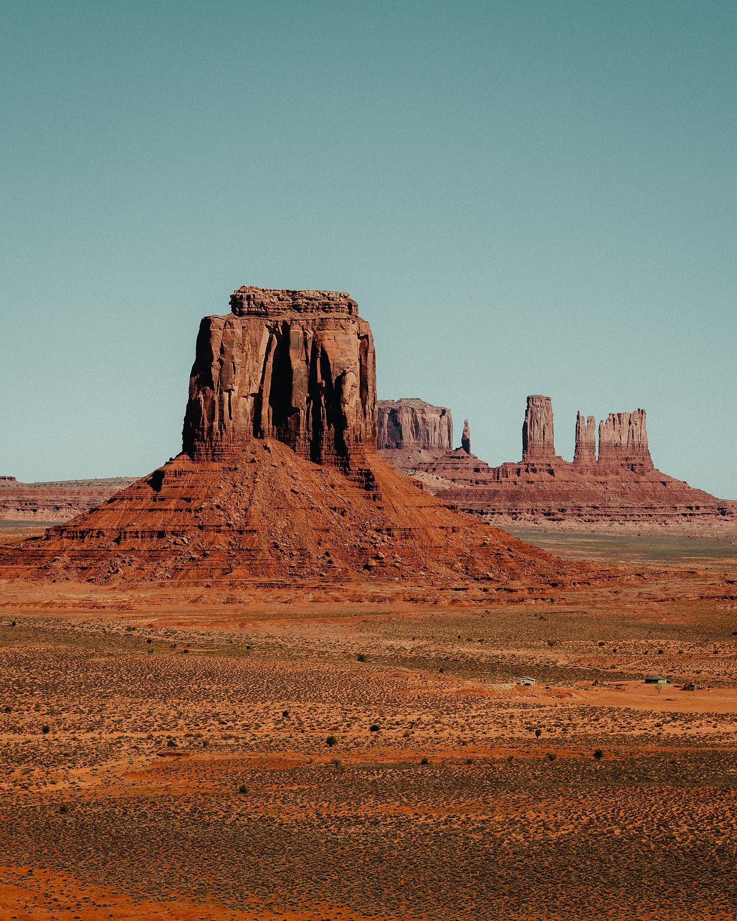 Iconic red sandstone buttes in Monument Valley with a clear blue sky.