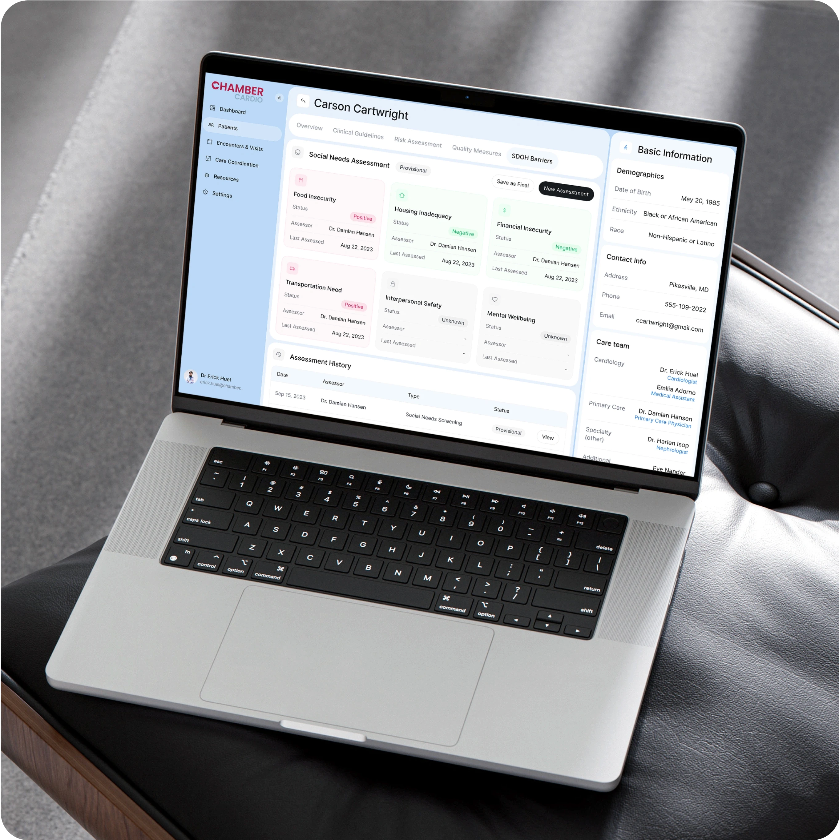 A laptop displaying the ChamberCardio patient dashboard for Carson Cartwright, with various sections providing detailed health and social information. Key features on the screen include:  Social Needs Assessment: Includes statuses for key areas such as "Food Insecurity" (Positive), "Housing Inadequacy" (Negative), "Financial Insecurity" (Negative), "Transportation Need," "Interpersonal Safety" (Unknown), and "Mental Wellbeing" (Unknown). Each area is color-coded to indicate severity or status. Basic Information: Displays demographics like the patient's date of birth (May 20, 1985), ethnicity (Black or African American), race (Non-Hispanic or Latino), and contact information. Care Team: Lists healthcare providers involved in the patient's care, such as Dr. Erick Huel (Cardiology) and Dr. Damian Hansen (Primary Care Physician). Assessment History: A timeline of recent assessments, including social needs screenings, conducted by Dr. Damian Hansen on September 19, 2023. The interface is organized with a clean layout, using soft colors for different statuses, making it easy to assess both medical and social factors at a glance. The design is professional and intuitive, supporting healthcare professionals in managing patient care effectively.