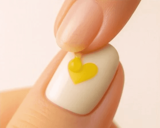 A close up of somone placing a small droplet of their drink on the GHB testing nail sticker that is yellow.