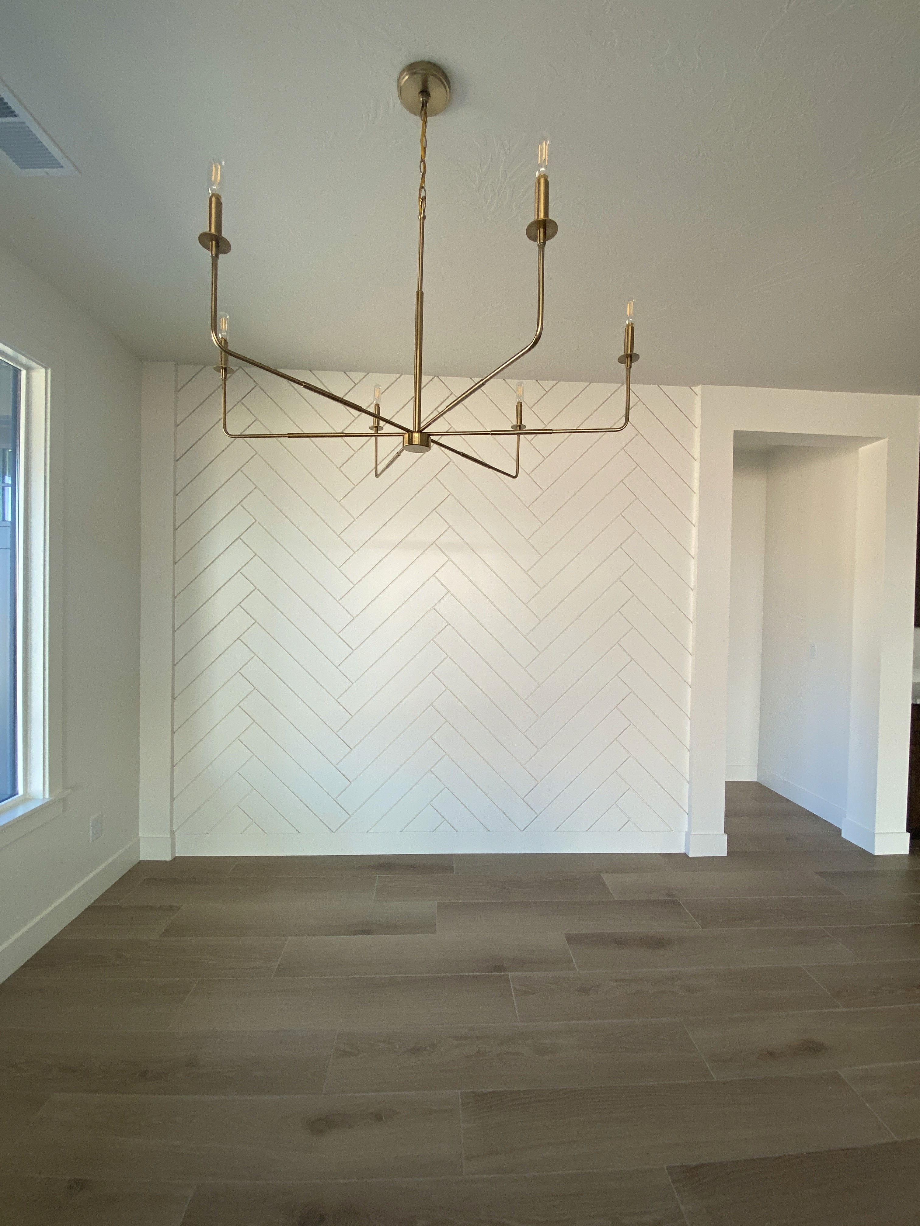 Dining room with white herringbone accent wall in a Hurricane, Utah custom home, creating a sophisticated focal point.