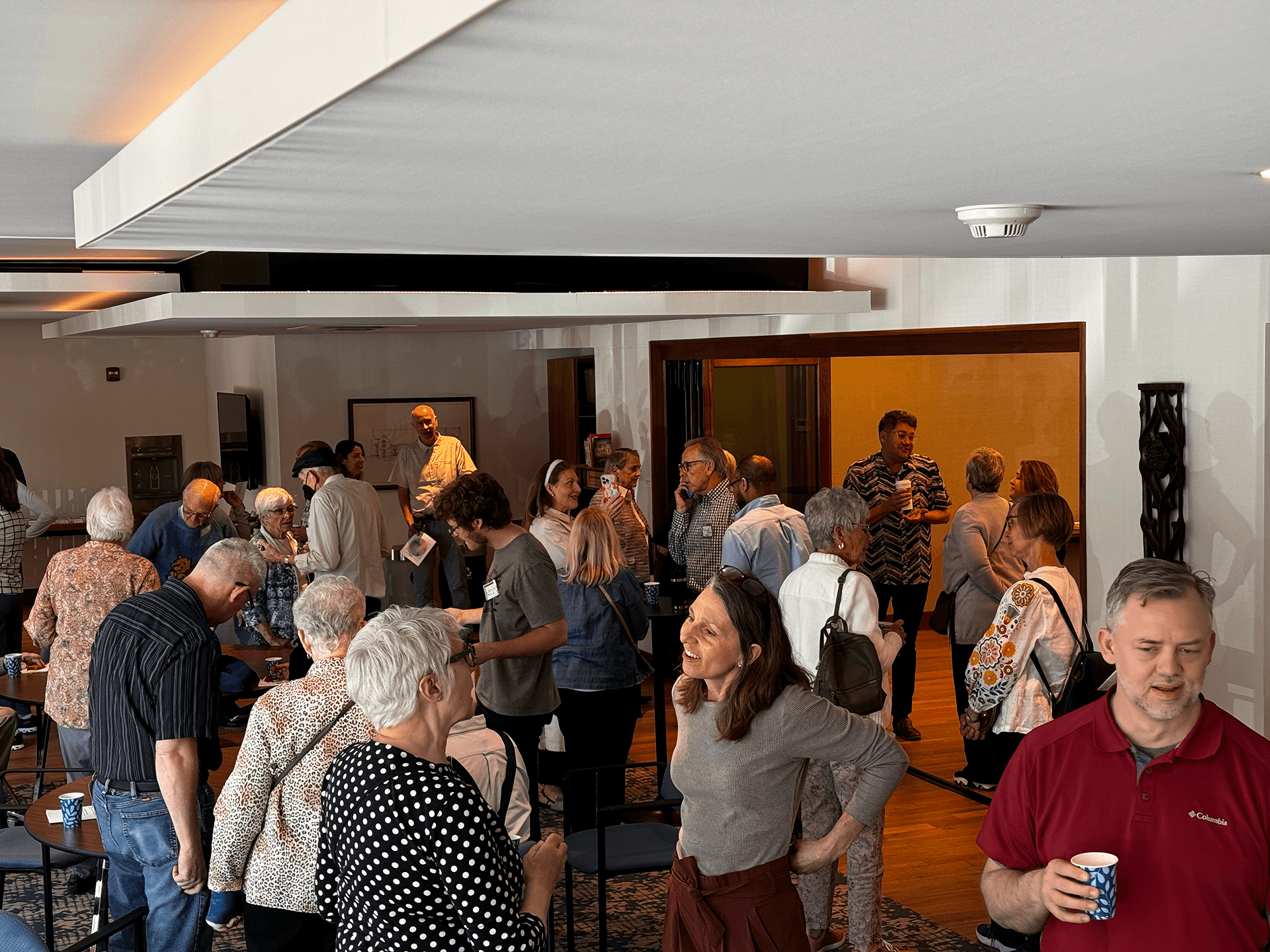 Group of four Grace Trinity Church members standing together, enjoying food and drinks during a casual event.