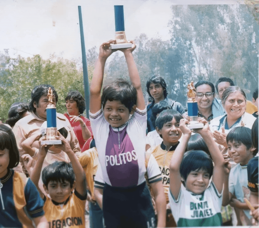 Marco Navarro en primer lugar del podio infantil levantando su trofeo, durante una premiación a finales de los 70.