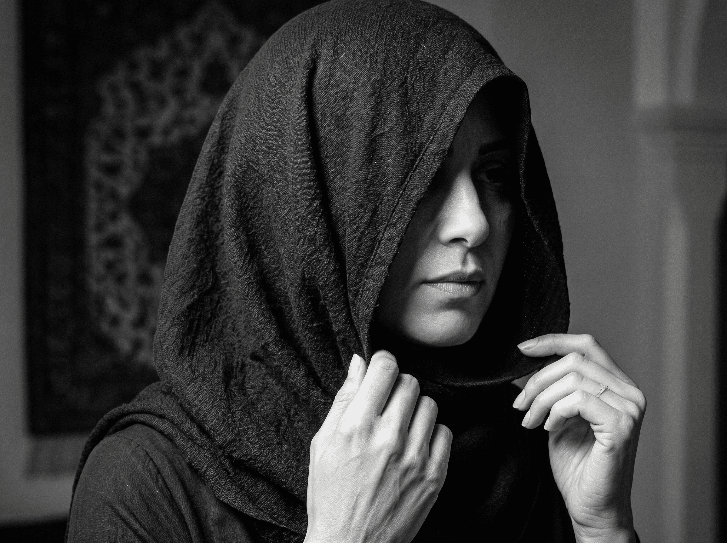 Portrait artistique en noir et blanc d’une femme portant un hijab sombre