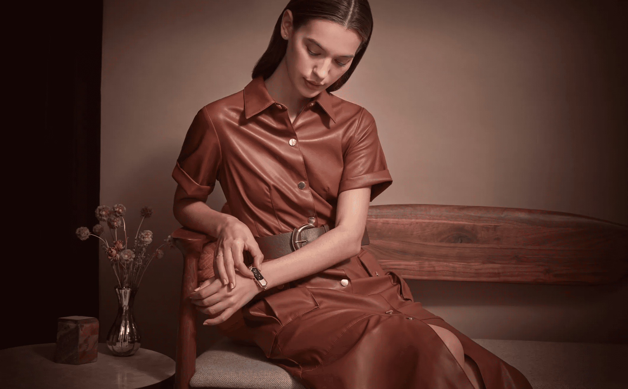 Talsam smart jewelry charms arranged with sculptural objects on a warm metallic surface