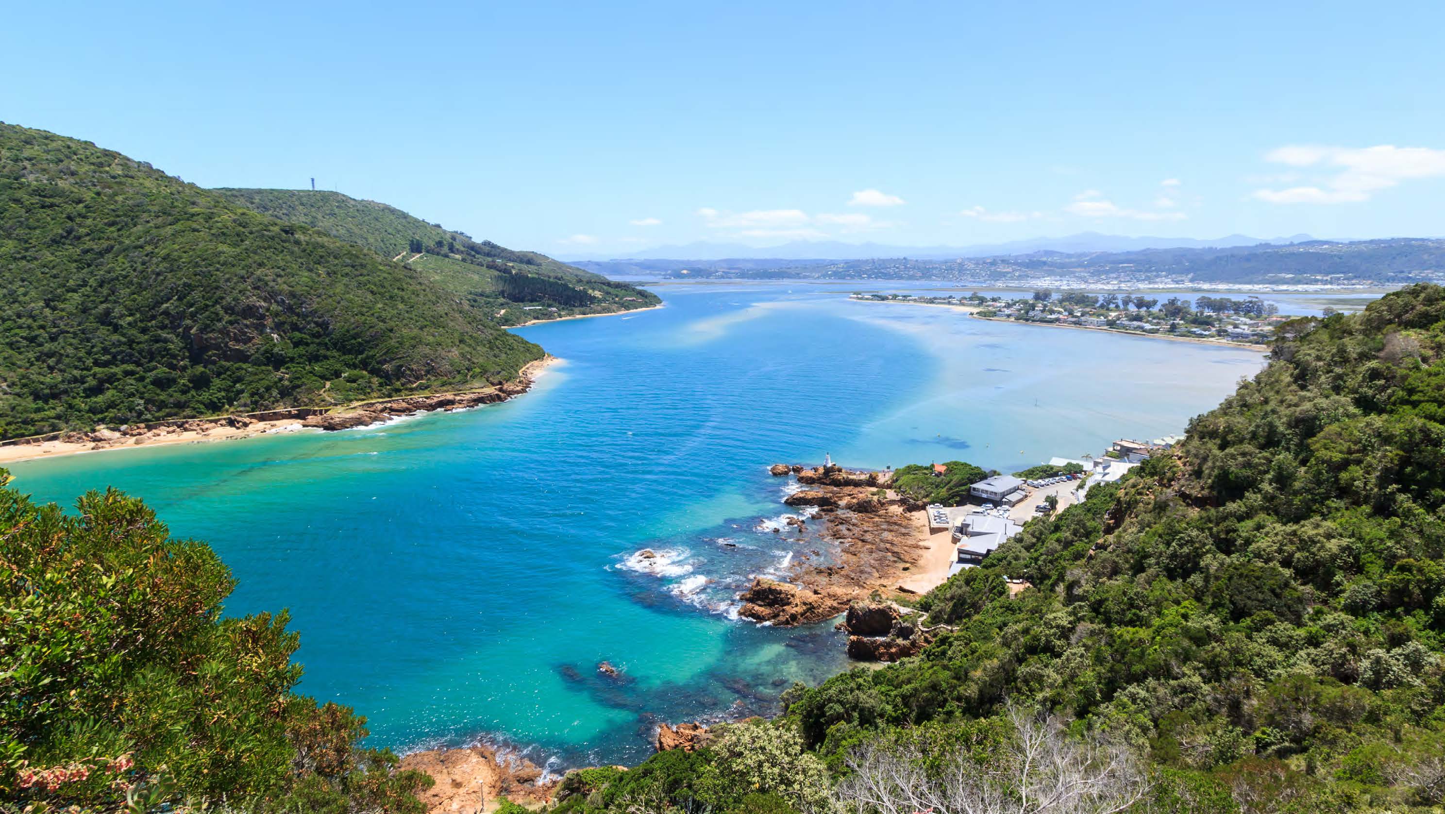 Lone woman walking near a large lake in the mountain with backpack on her back