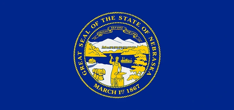 Flag of Nebraska featuring the state seal centered on a blue background. The seal includes a steamboat, train, and mountains with the motto "Equality Before the Law."