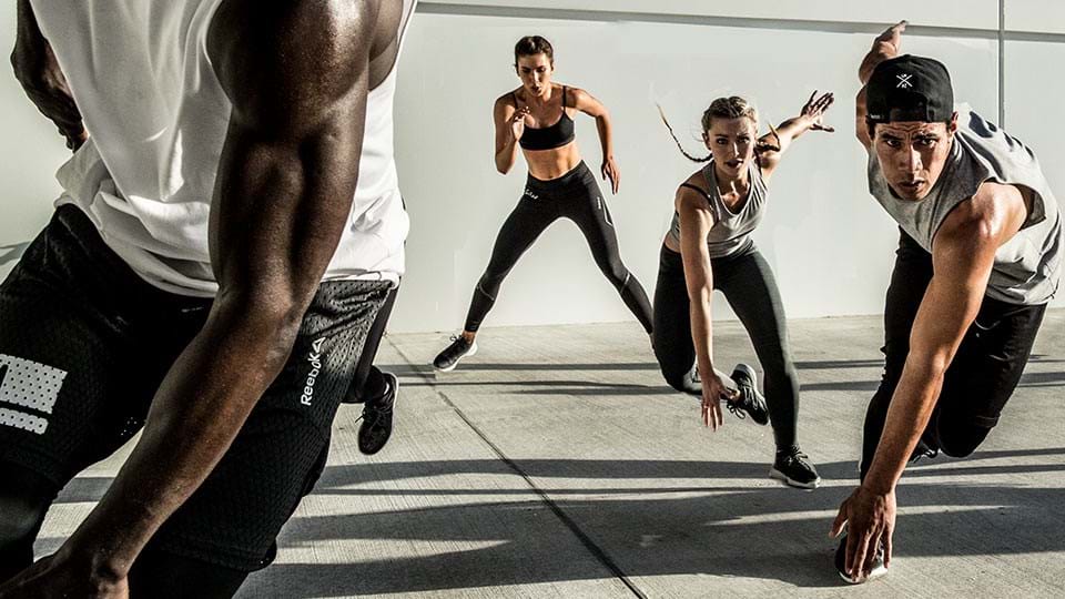 Vier Personen in Sportkleidung beim intensiven Zirkel-Training.
