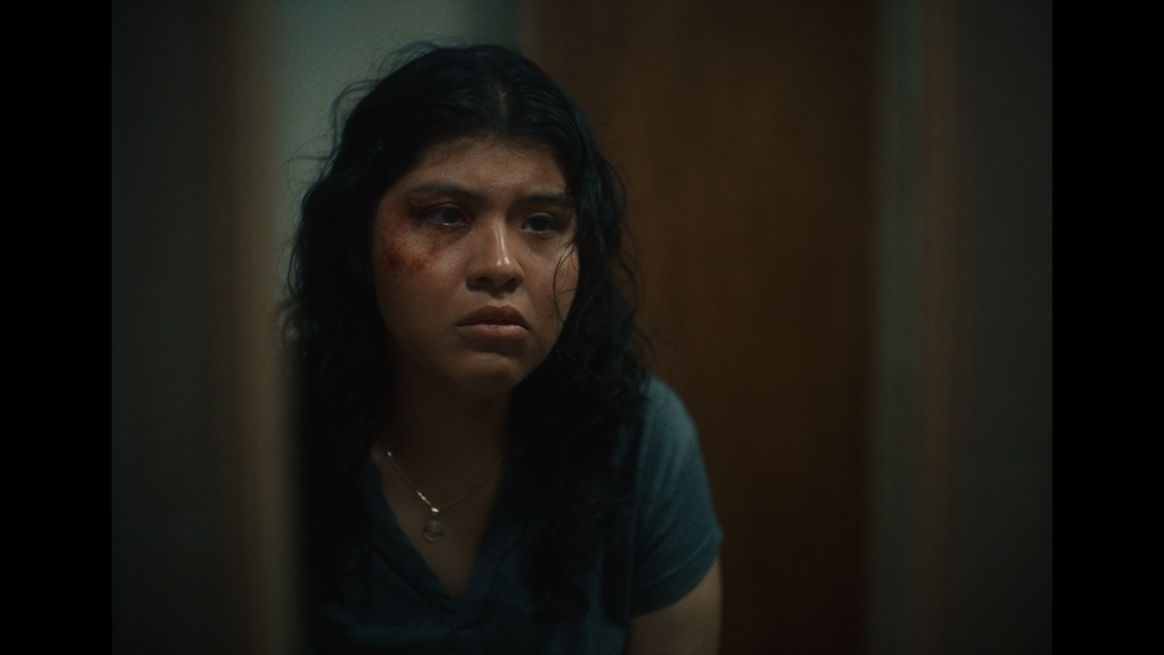 View of the French countryside through a stone villa’s open living room, with sofas and trees framing the scene
