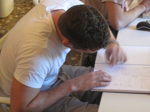 A photo of a person sketching something in a notebook.