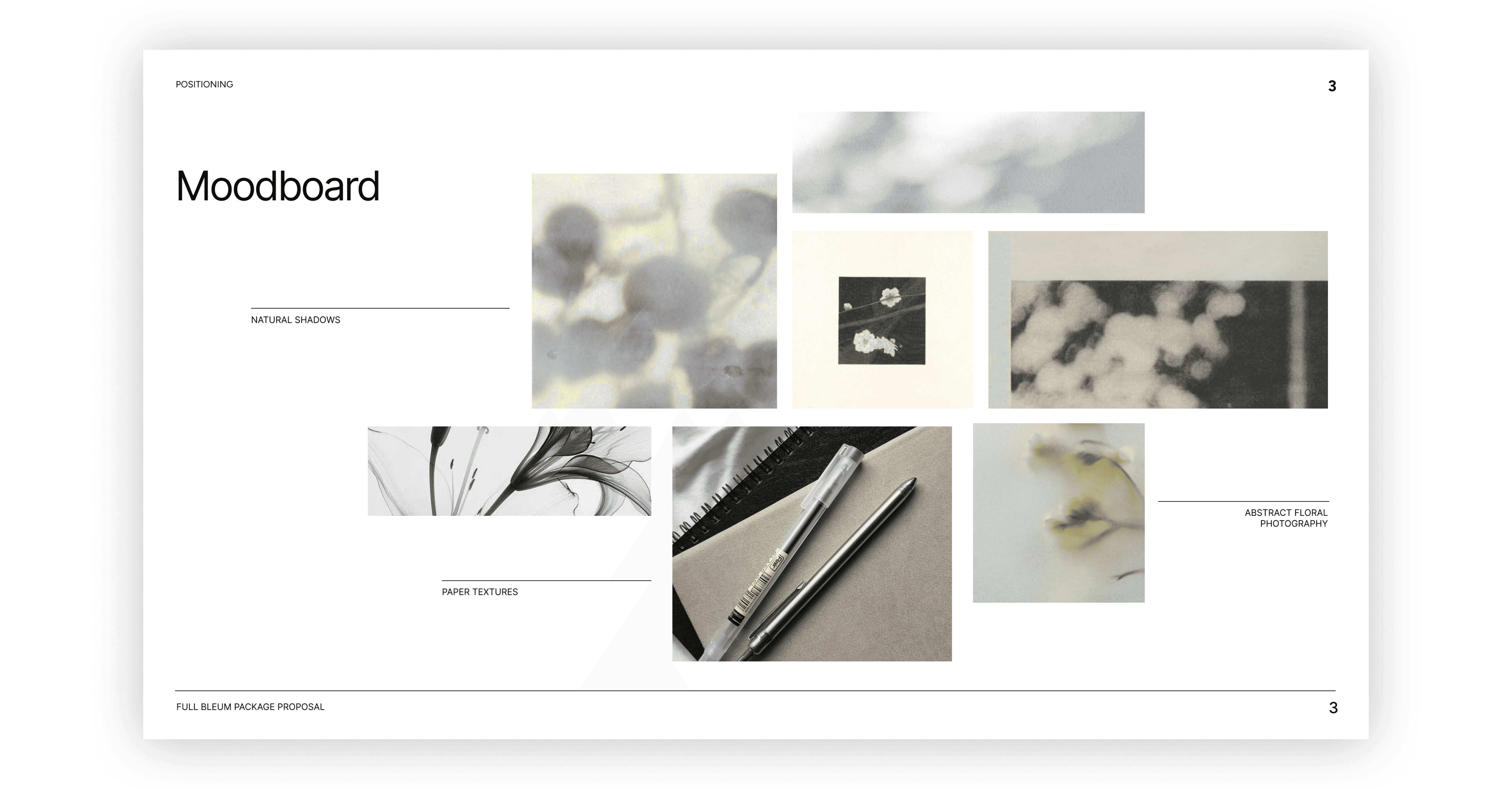 A young person with curly hair smiles at the camera while sitting in front of a laptop against a dark background.