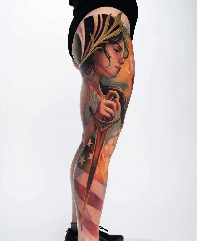 Winged figure tattoo with sun and geometric details.