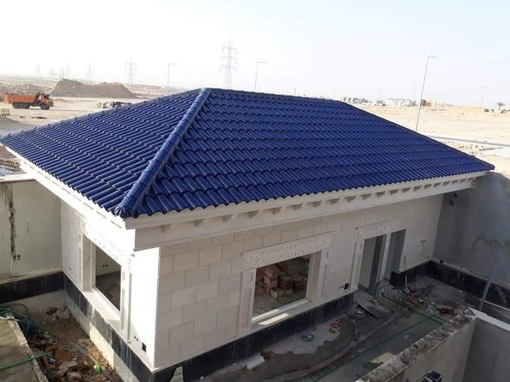Wind turbine, house with solar panels, person on scooter