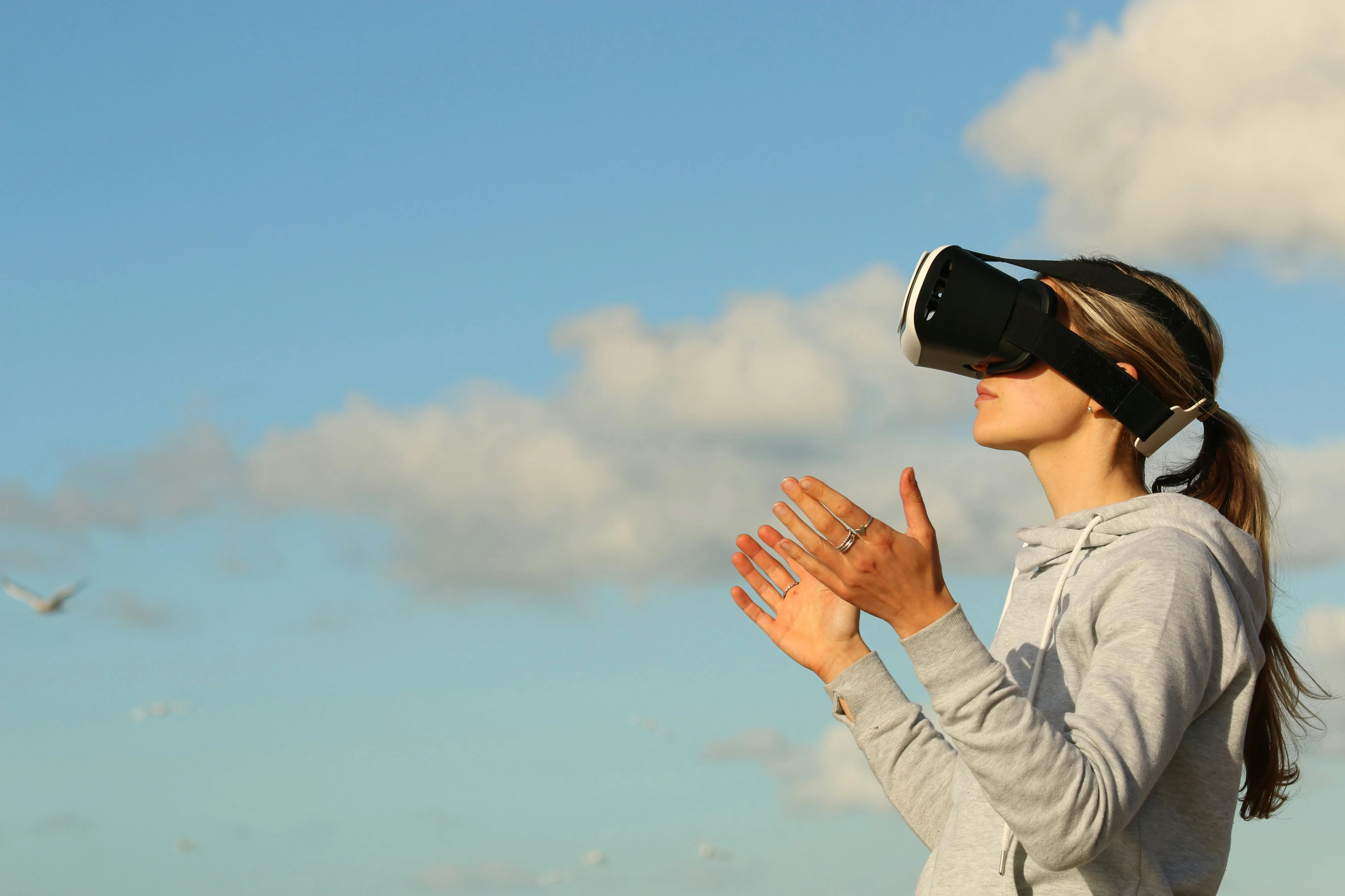 High school student exploring virtual reality outdoors with VR headset, showcasing immersive learning and innovative tech experiences for curious high schoolers.