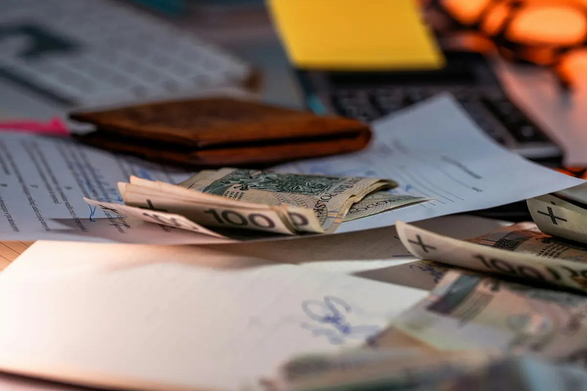 Money, documents, and a laptop on a table