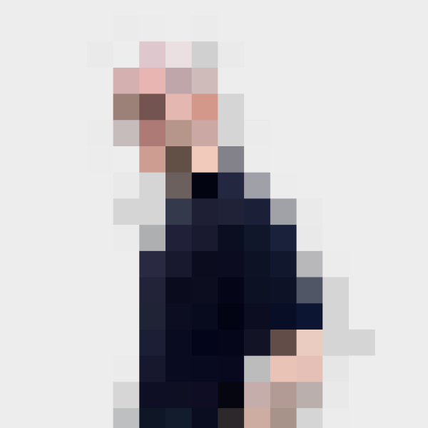 Pixelated portrait of the designer wearing a dark outfit against a light background.