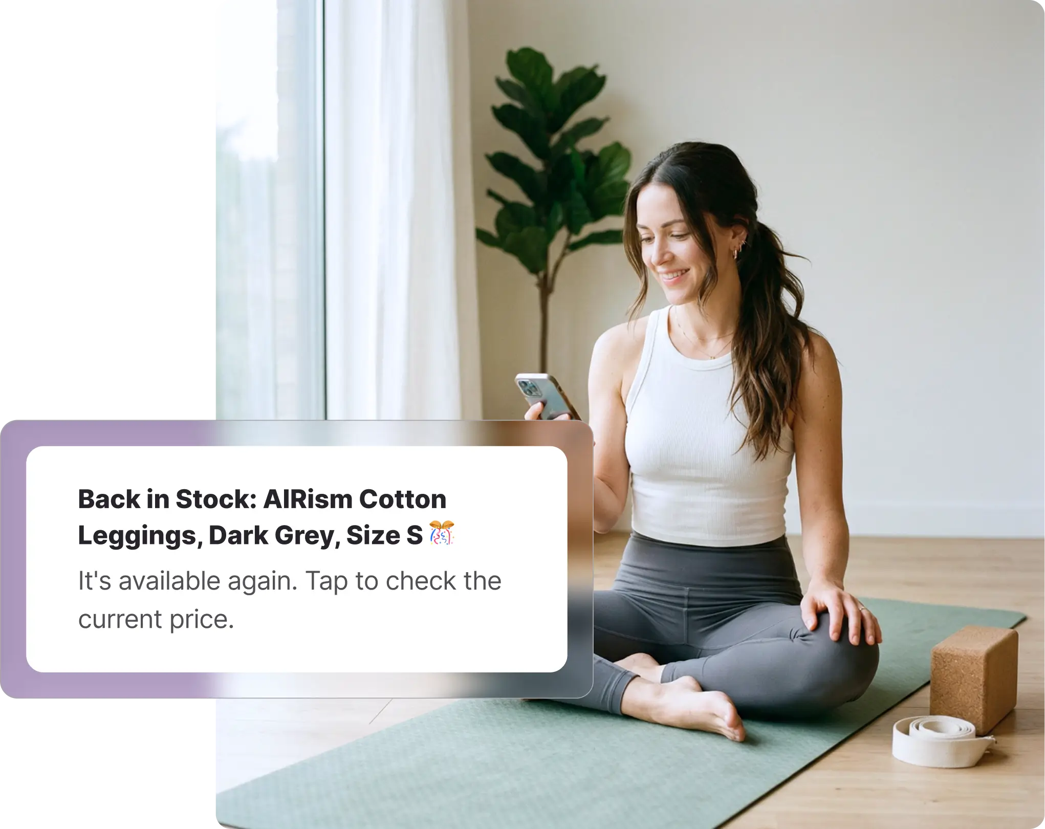 A smiling woman sitting cross-legged on a green yoga mat looking at her smartphone, with a yoga block and strap nearby. Overlaid on the image is a Whisprice digital notification displaying a back-in-stock alert for a Uniqlo product, specifically "AIRism Cotton Leggings, Dark Grey, Size S," prompting the user to tap and check the current price.