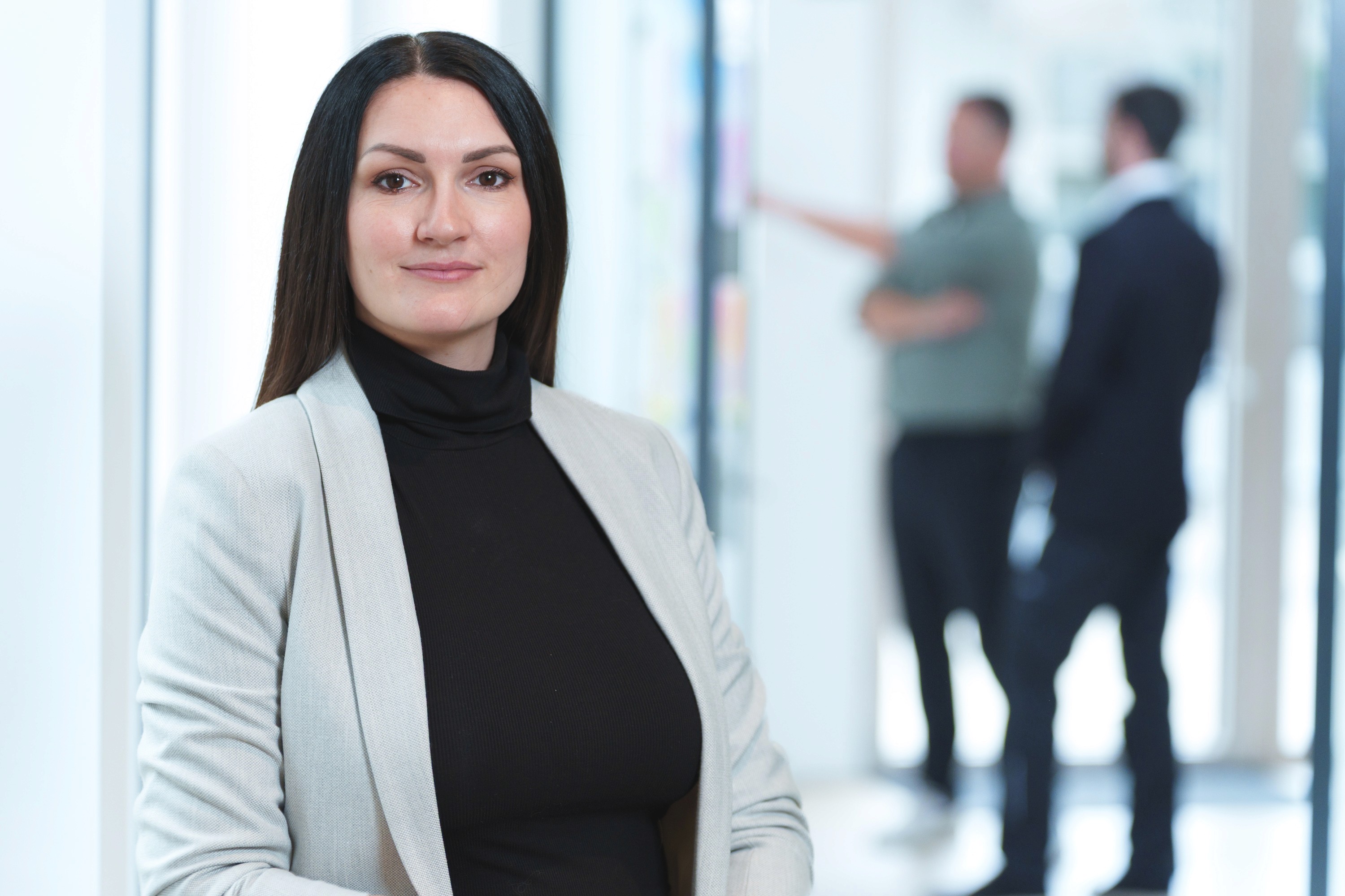 Business Portrait einer Frau mit Kollegen im Hintergrund