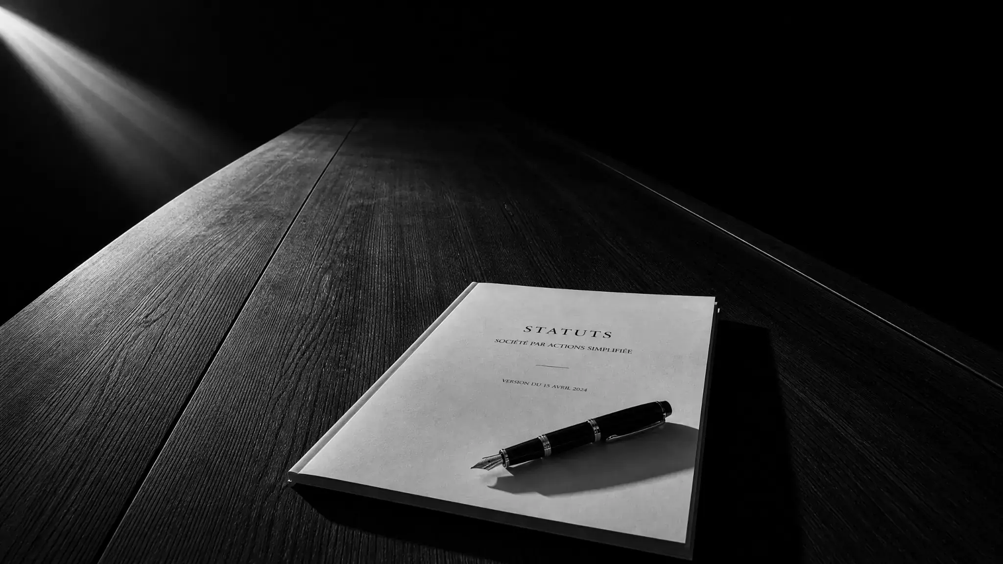 Statuts d'une société par actions simplifiée (SAS) posés sur un bureau, illustrant l'accompagnement en création et structuration de sociétés par STC Avocat.