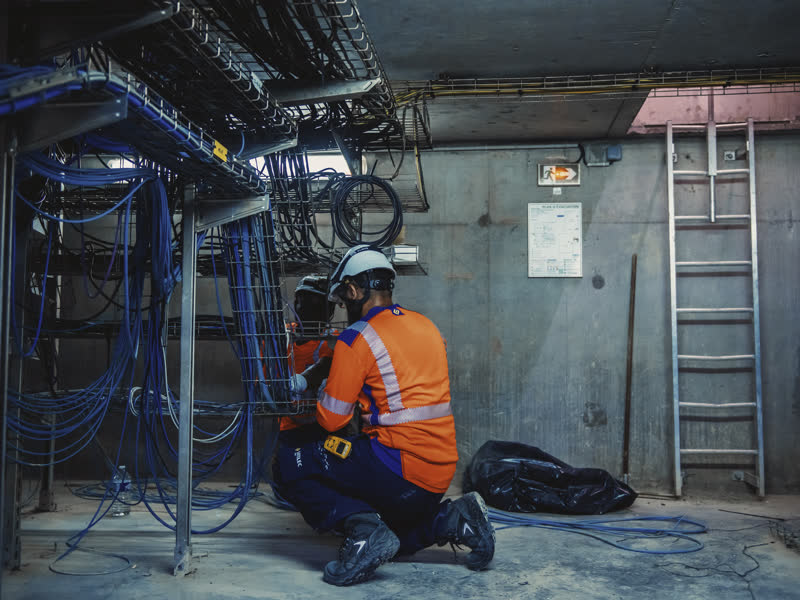 Électricien intervenant sur une installation en local technique