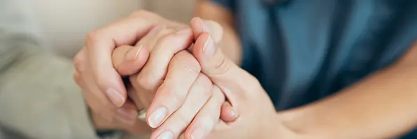 Care giver holding the hand of a elderly woman 