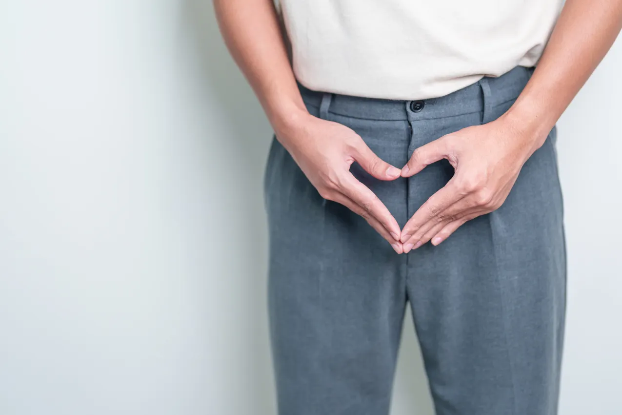 man holding hands like a heart in front of pelvis