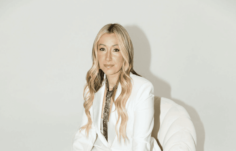 Portrait of a person in a pink sweater against a light background