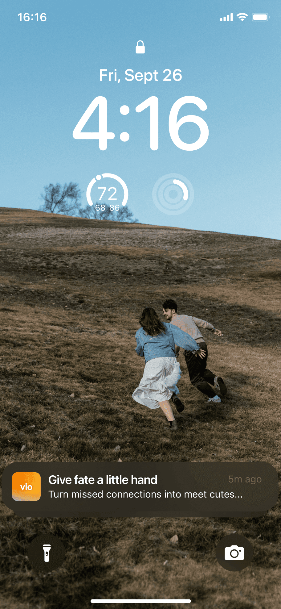 a homescreen showing a couple running up a hill with a notification from the via app that says give fate a little hand; turn missed connections into meet cutes